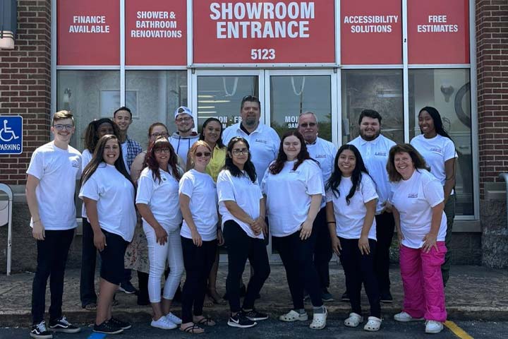 team members posing for picture in white shirts.